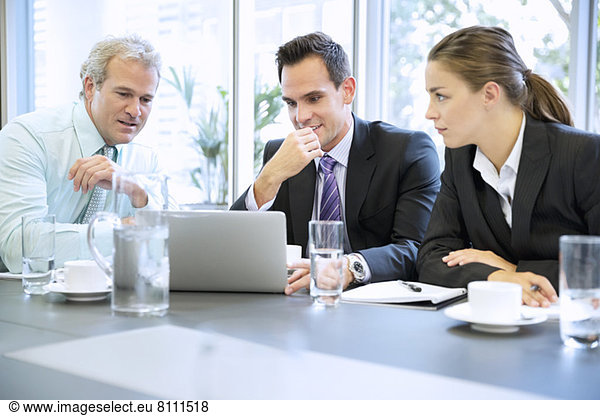 Business people sharing laptop in meeting