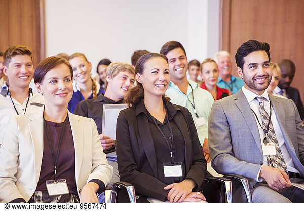 Business people sitting in conference room  smiling and looking away