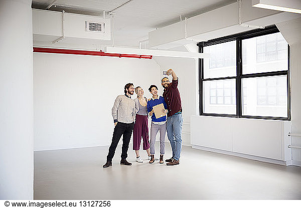 Business people taking selfie in new office