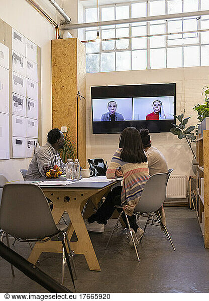 Business people video conferencing with colleagues on screen