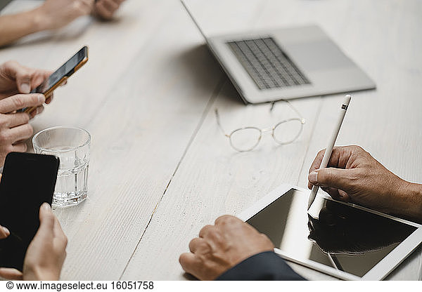 Business people working in office using portable devices close up