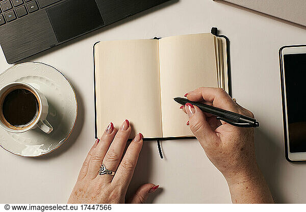 Business still live of an unrecognizable woman writing in a notebook