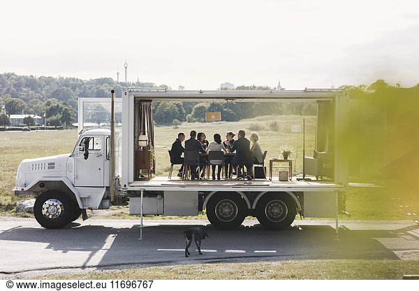 Business team working in portable office truck on road