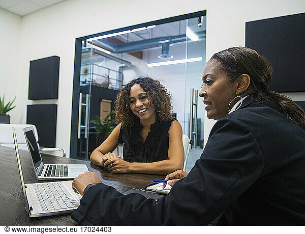 Business women using laptops in office