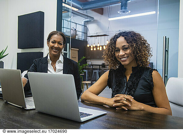 Business women using laptops in office