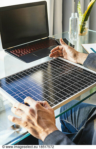 Businessman analyzing solar panel at desk in home office