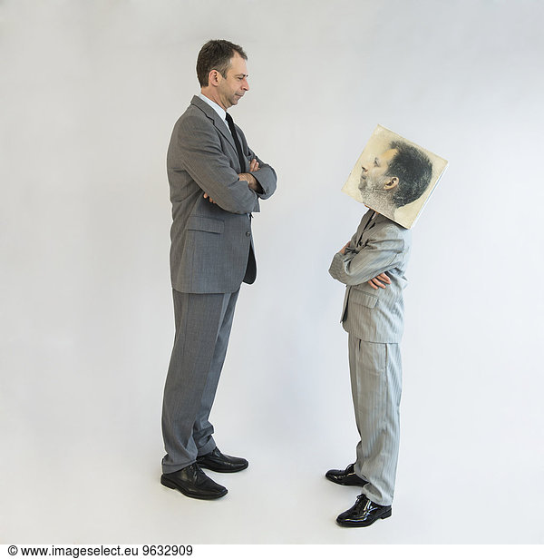 Businessman and boy wearing mask standing face to face