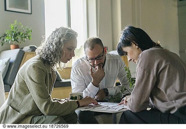Businessman and businesswoman having a meeting with client in architect's office
