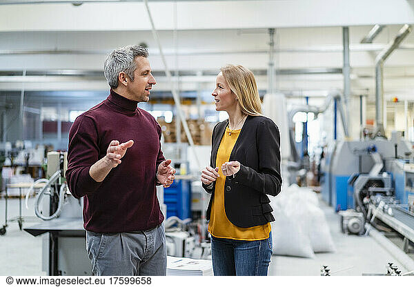 Businessman and businesswoman planning together in factory