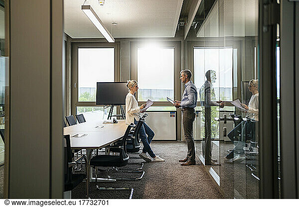 Businessman and businesswoman talking in office