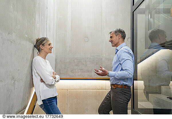 Businessman and businesswoman talking on stairs in office