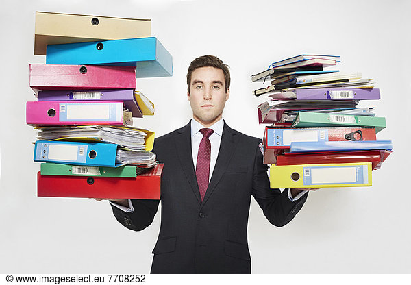 Businessman balancing stacks of folders