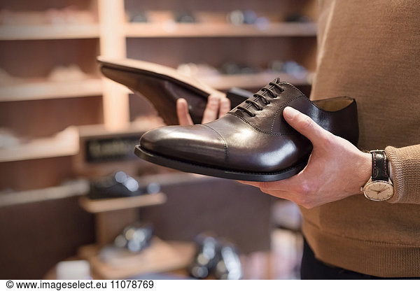 Businessman browsing dress shoes in menswear shop