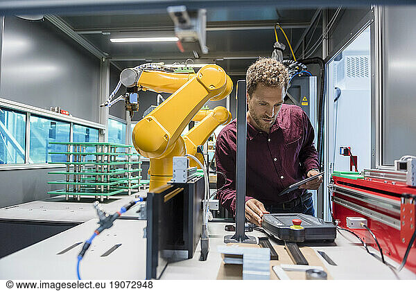 Businessman checking industrial robot in high tech company