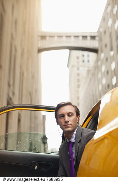 Businessman climbing out of taxi