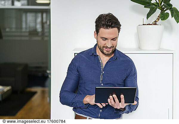 Businessman concentrating and working on tablet PC in office