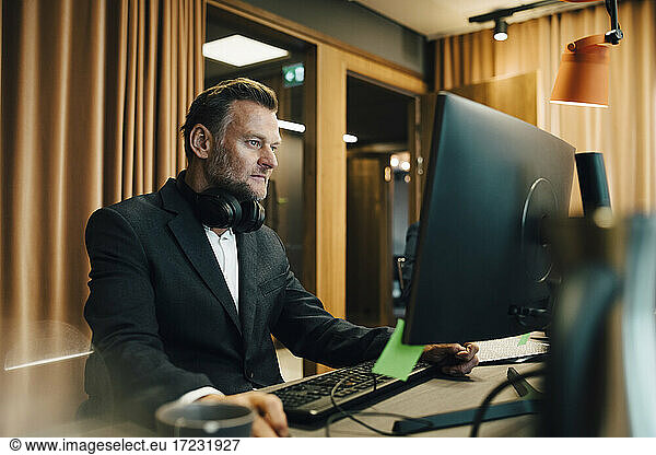 Businessman concentrating while working on computer in office