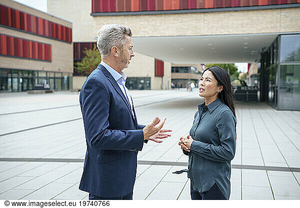Businessman discussing with businesswoman in office park