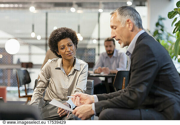 Businessman discussing with colleague in meeting at office