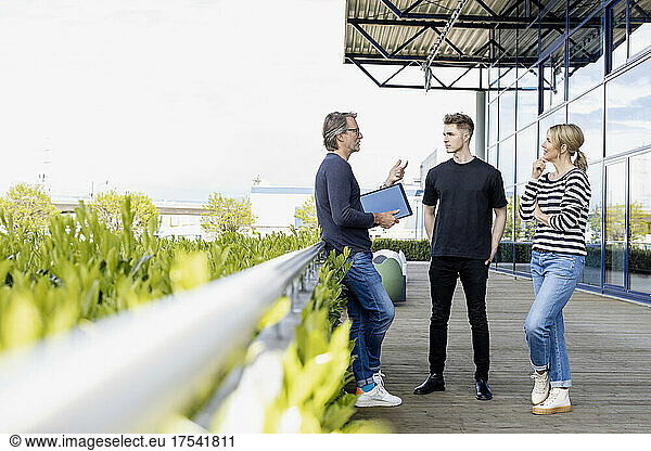 Businessman discussing with colleagues at rooftop