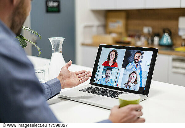Businessman discussing with colleagues in web conference at home office