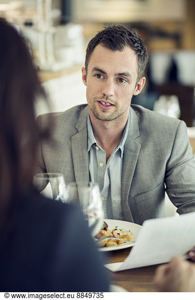 Businessman discussing with female colleague at restaurant table