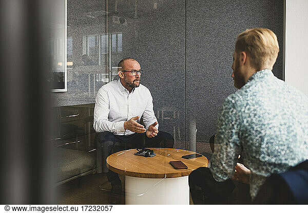 Businessman discussing with male colleagues in office
