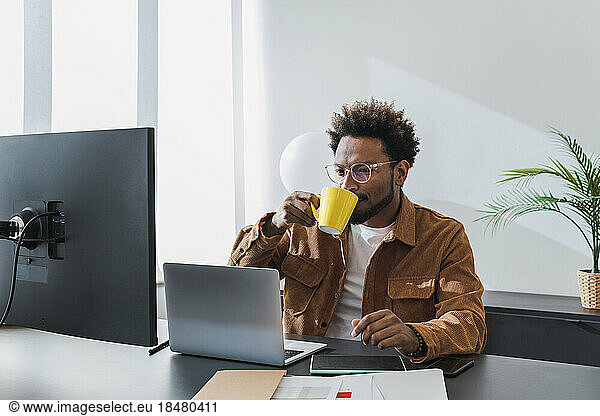 Businessman drinking coffee and working in office