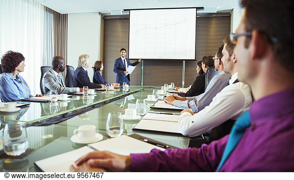 Businessman giving presentation to colleagues in conference room
