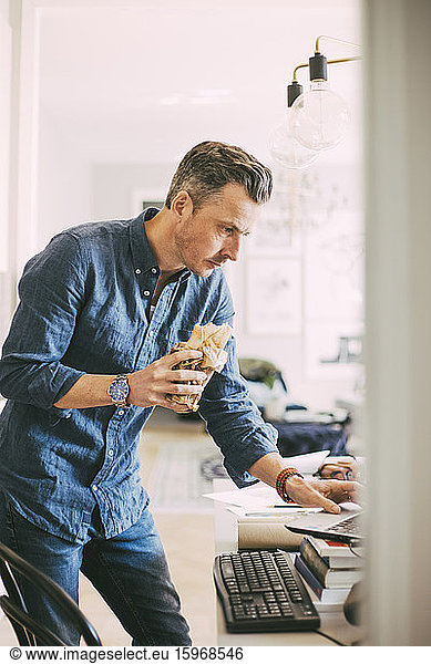 Businessman having lunch working from home