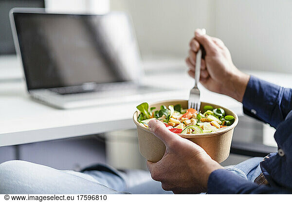 Businessman having salad in office