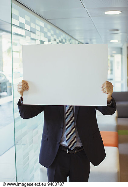 Businessman holding cardboard in office building