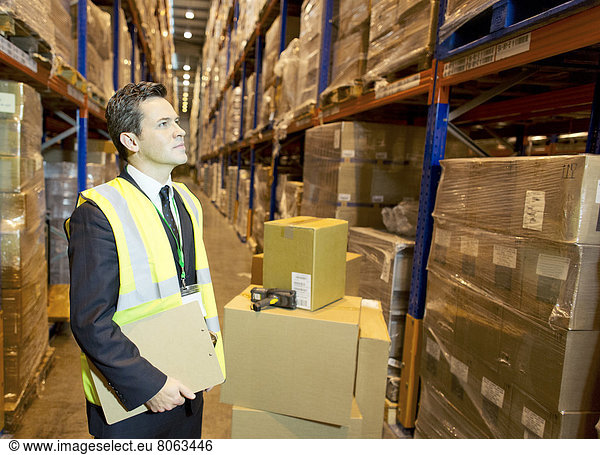 Businessman holding clipboard in warehouse