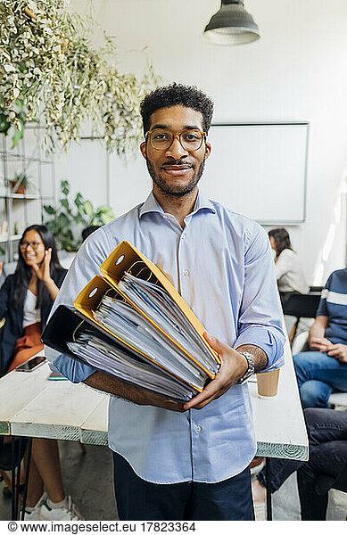 Businessman holding file folders at coworking office