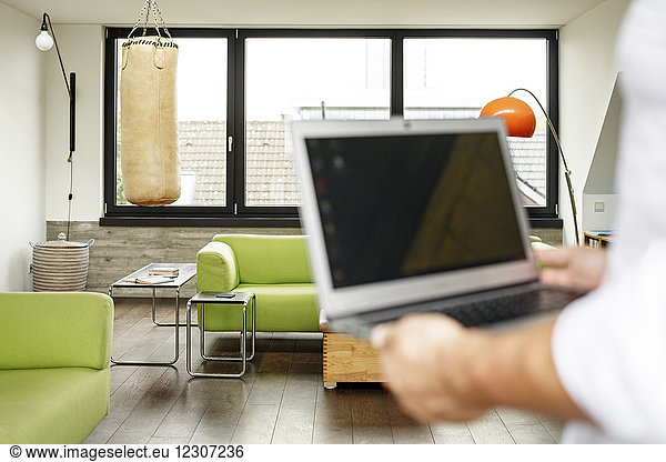Businessman holding laptop punch bag in the background