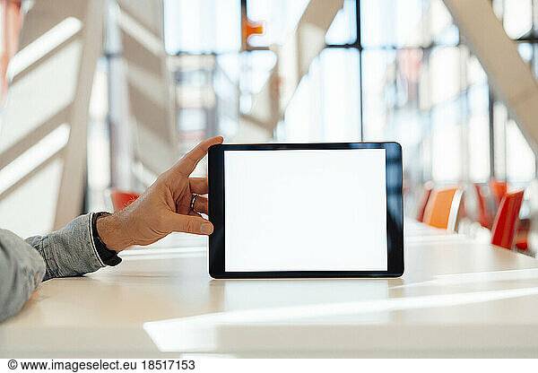 Businessman holding tablet PC on table