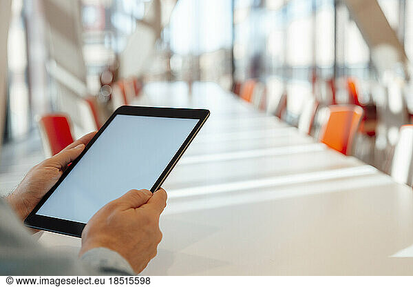 Businessman holding tablet PC sitting at table