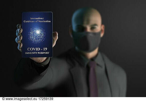 Businessman in face mask with COVID-19 immunity passport