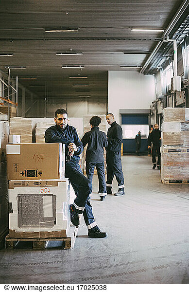 Businessman leaning on box containers in warehouse