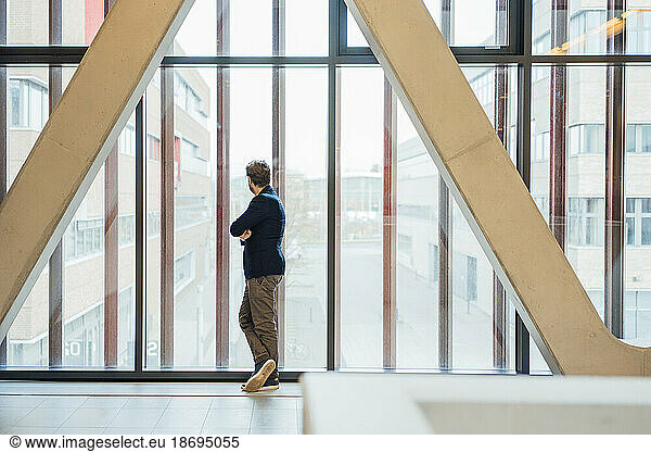 Businessman looking out of glass window