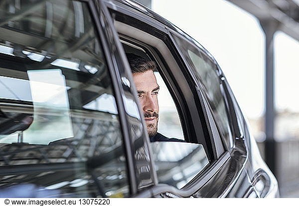 Businessman looking through car window