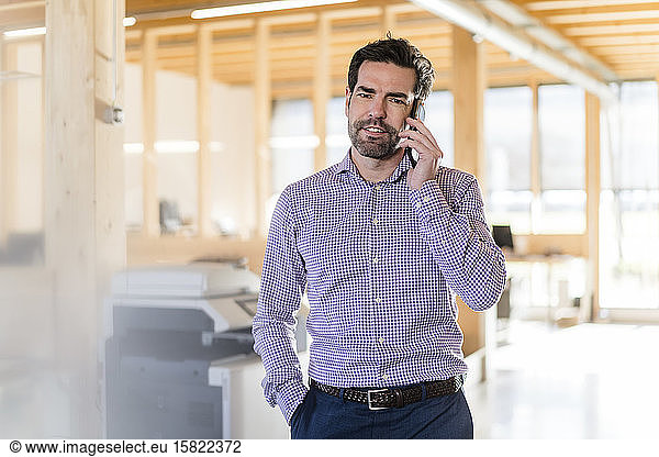 Businessman on the phone in wooden open-plan office