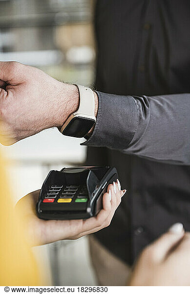 businessman paying with smart watch on card reader machine