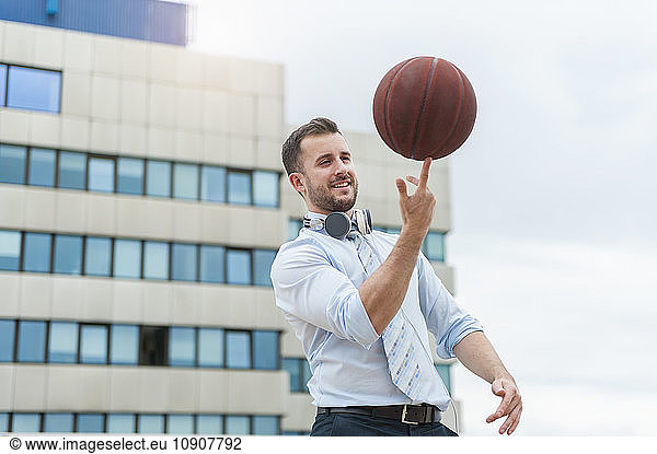 Businessman playing basketball outdoors