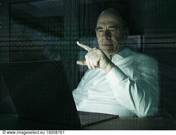 Businessman pointing on graphical user interface with binary codes in office
