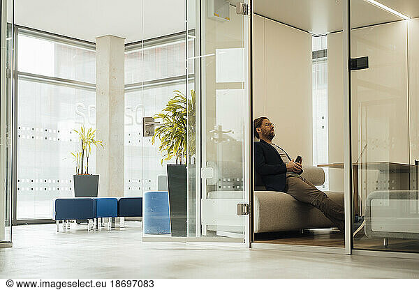 Businessman relaxing on couch in lobby