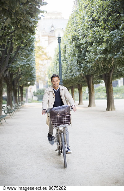 Businessman riding bicycle in park  Paris  France