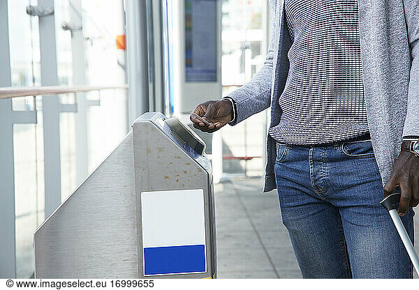 Businessman scanning ticket at gate of railroad station