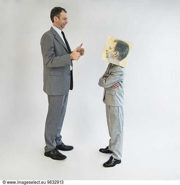 Businessman showing thumbs up to boy wearing mask