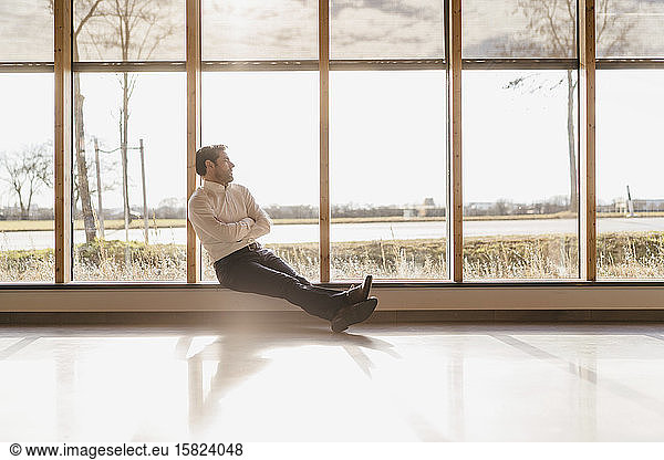 Businessman sitting at the window in open-plan office